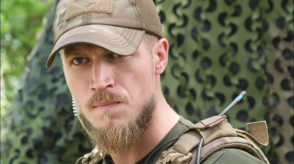 Військовослужбовець Олександр Ширшин або емблема 16-го армійського корпусу на тлі військової техніки